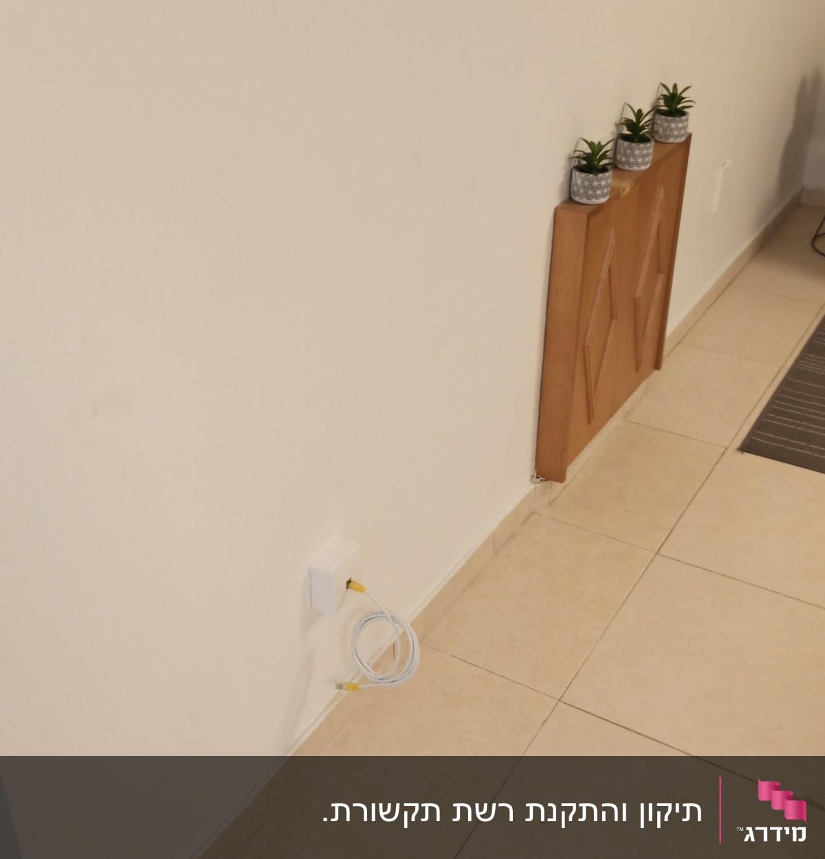 כבל רשת מחובר לשקע בקיר לבן